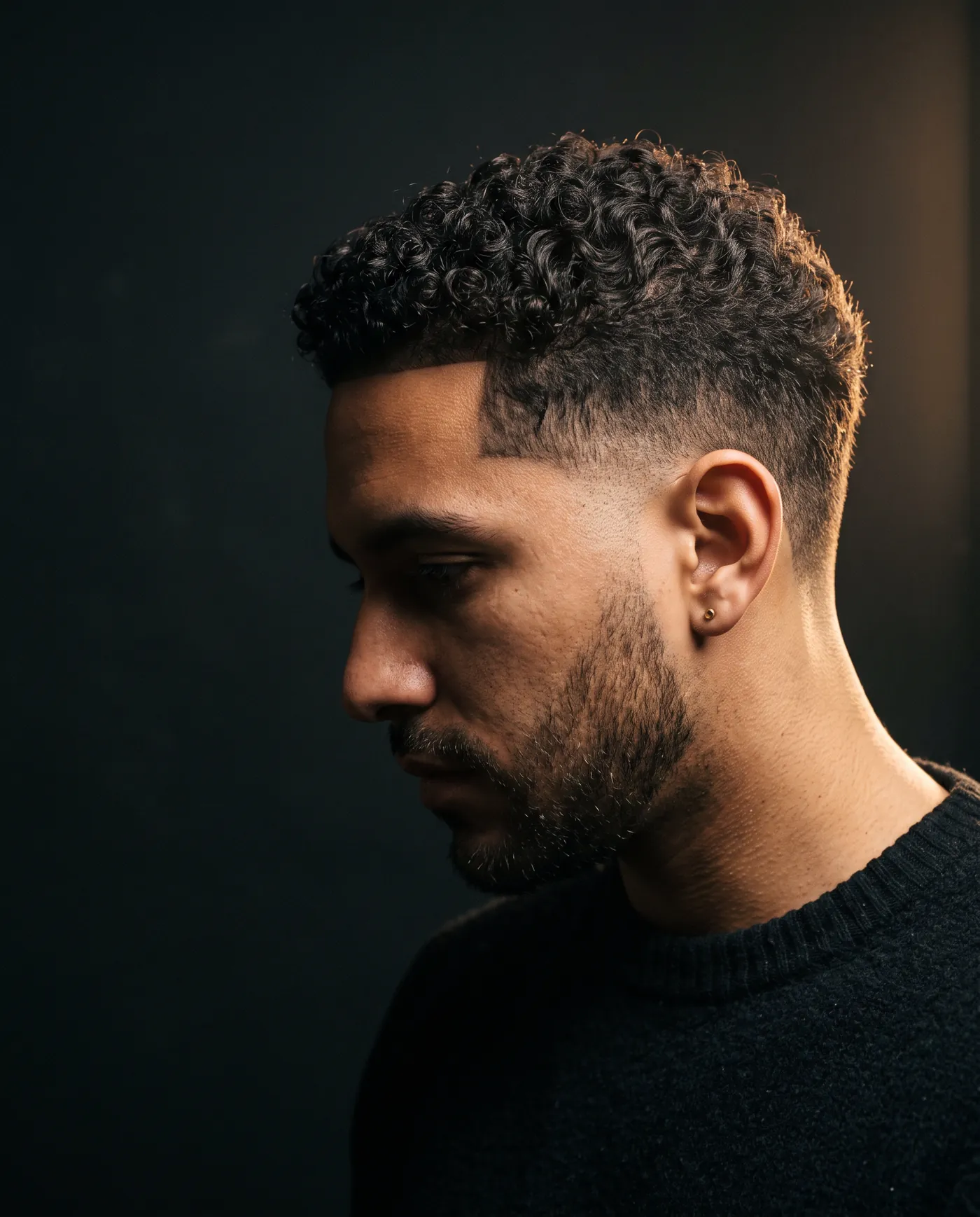Side profile of textured curls with a clean low taper at the temple